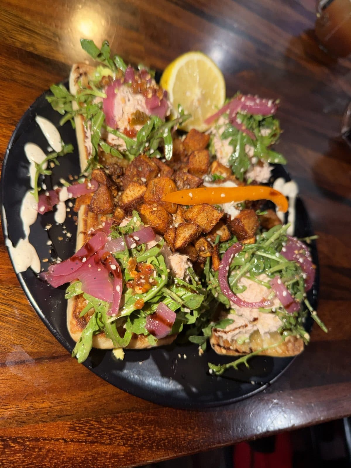 Italian Tuna Toast with house tuna salad, avocado smash, pickled red onion, arugula and everything seasoning on grilled ciabatta